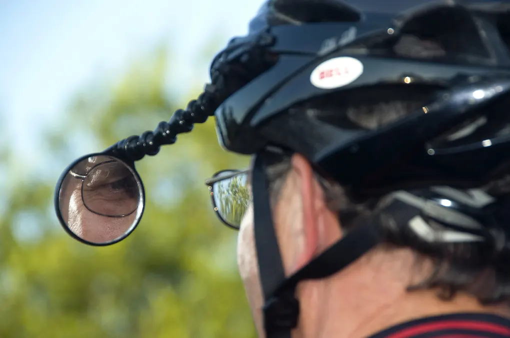 Bicyclist with a rearview mirror attached to his helmet
