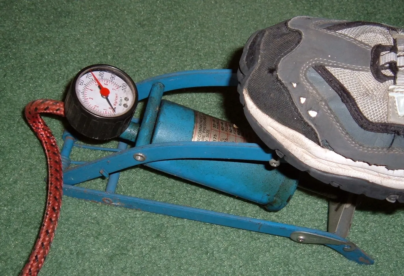 A foot-operated pump with hose and gauge.