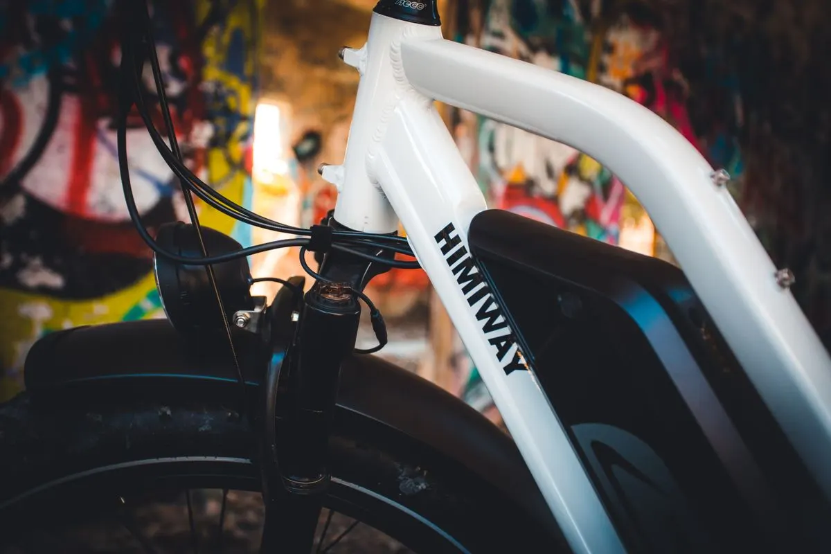 A detailed close-up of a Himiway electric bike with vibrant graffiti background, perfect for urban themes.