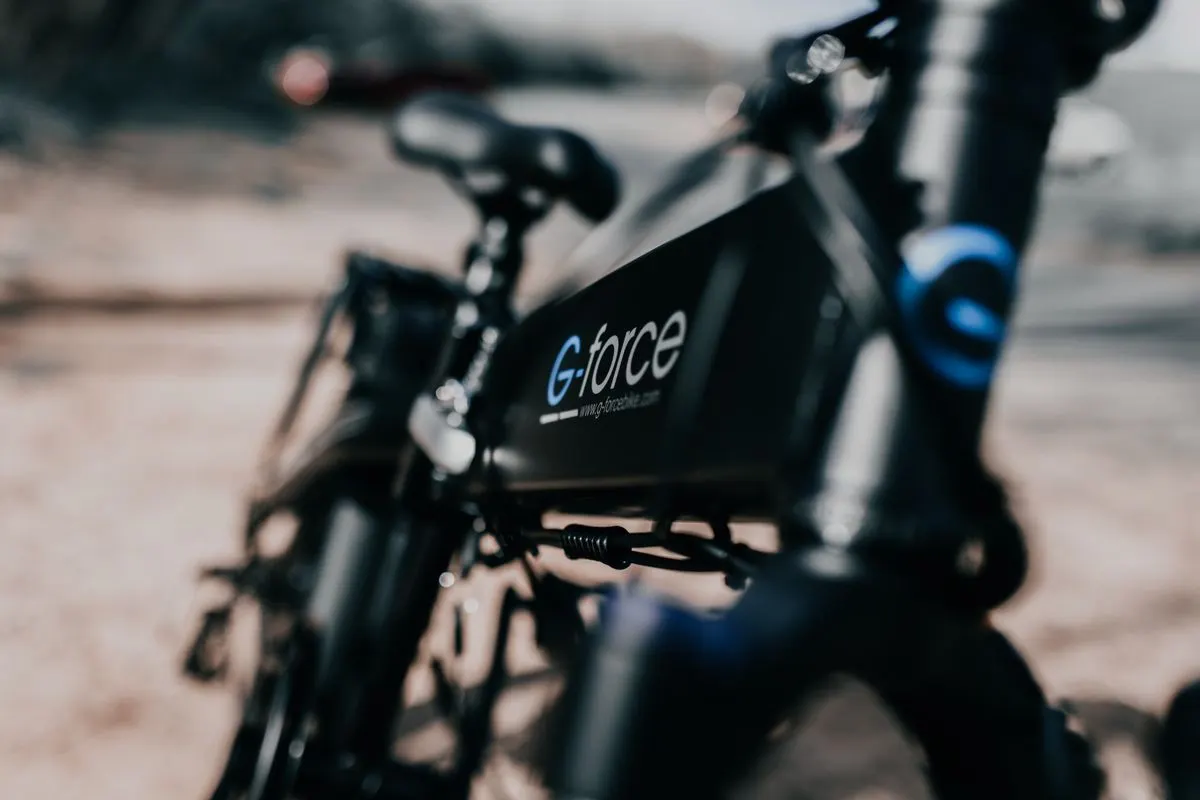 Detailed view of a sleek black electric bike with a blurred background, showcasing modern transportation.