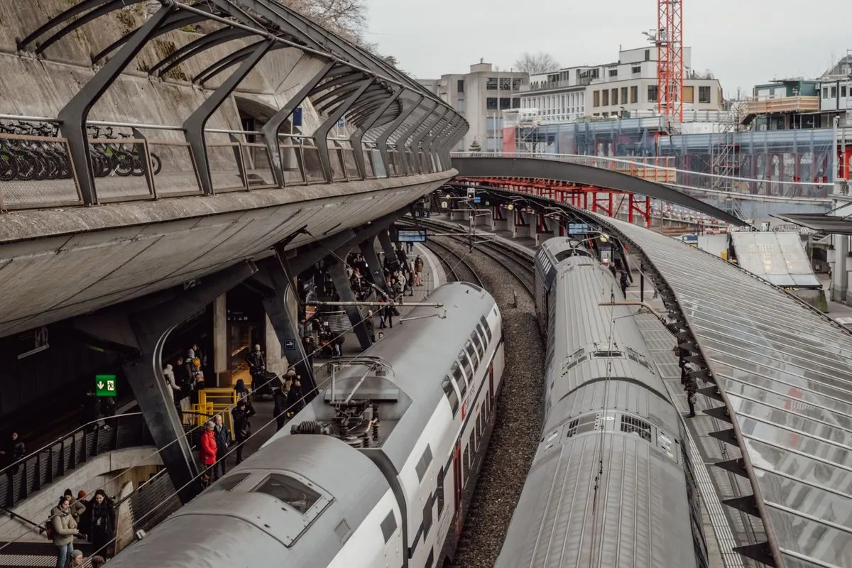 Aerial view of bustling train station in Zurich, Switzerland with modern architecture and commuter activity.