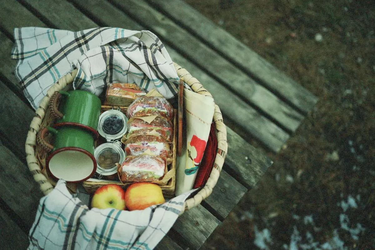 Picnic food and containers arranged in a basket