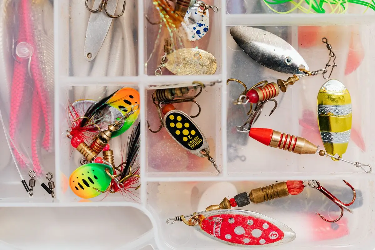 Assorted fishing lures in a tackle box, perfect for angling enthusiasts.