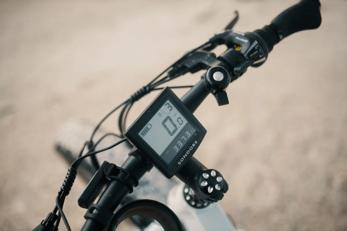Detailed view of a bicycle's handlebars featuring a digital speedometer and display.