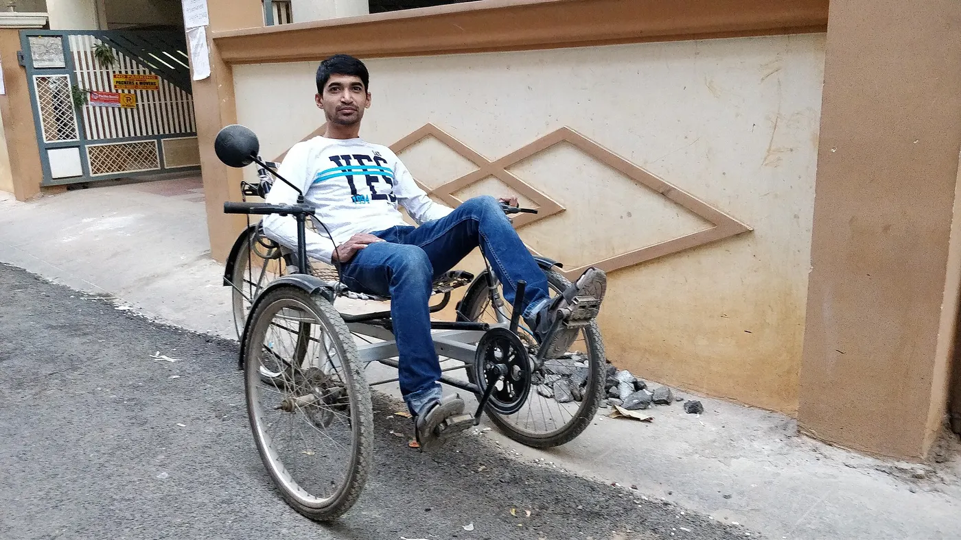 A recumbent tricycle with a supported seat and forward pedals.